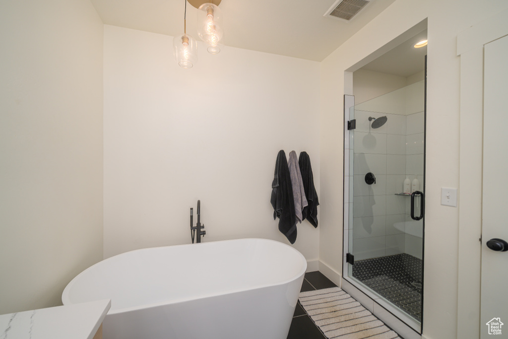 Bathroom with a soaking tub, a shower stall, and tile patterned floors