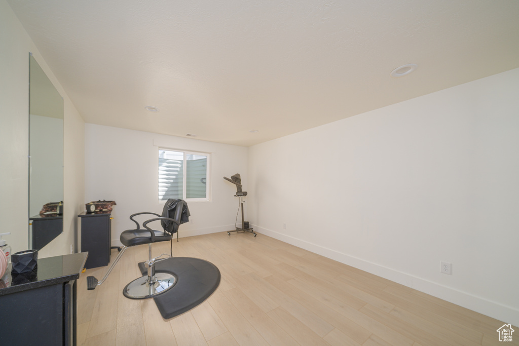 Exercise area with light wood finished floors and baseboards