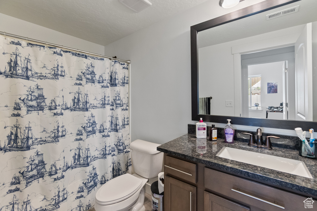 Bathroom featuring vanity, a shower with curtain, and a textured ceiling