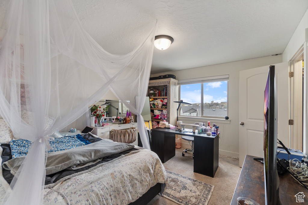 Bedroom with an office area and carpet
