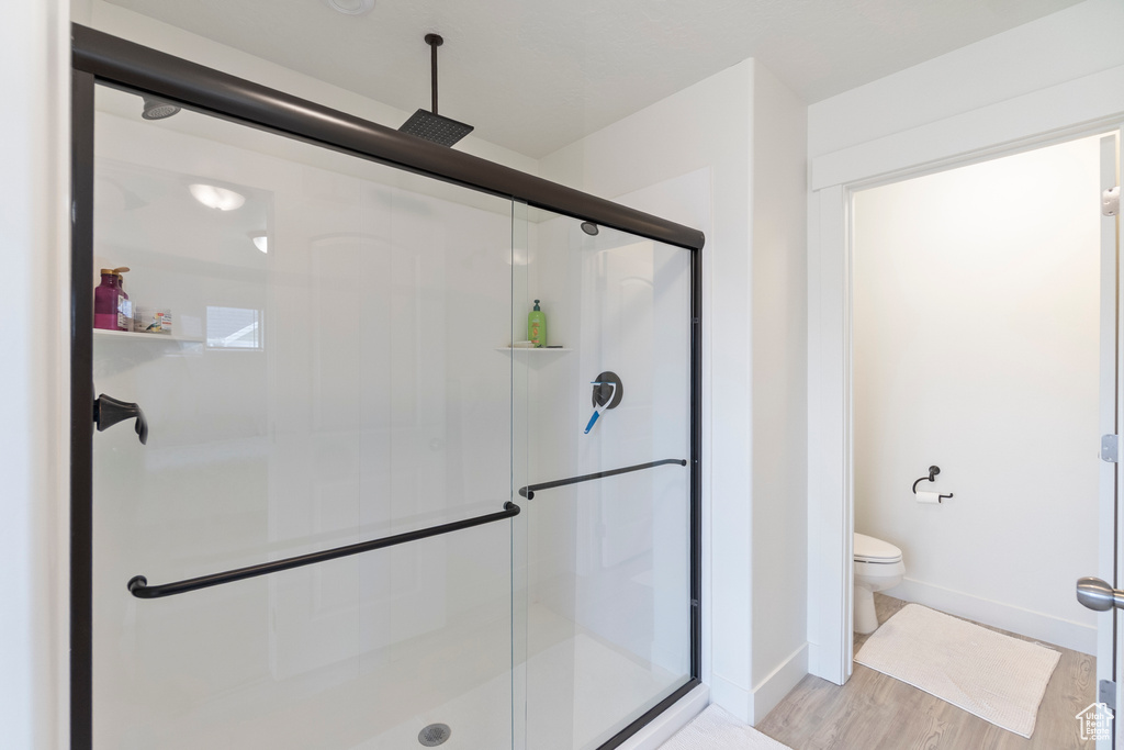 Full bath with a shower stall and wood finished floors