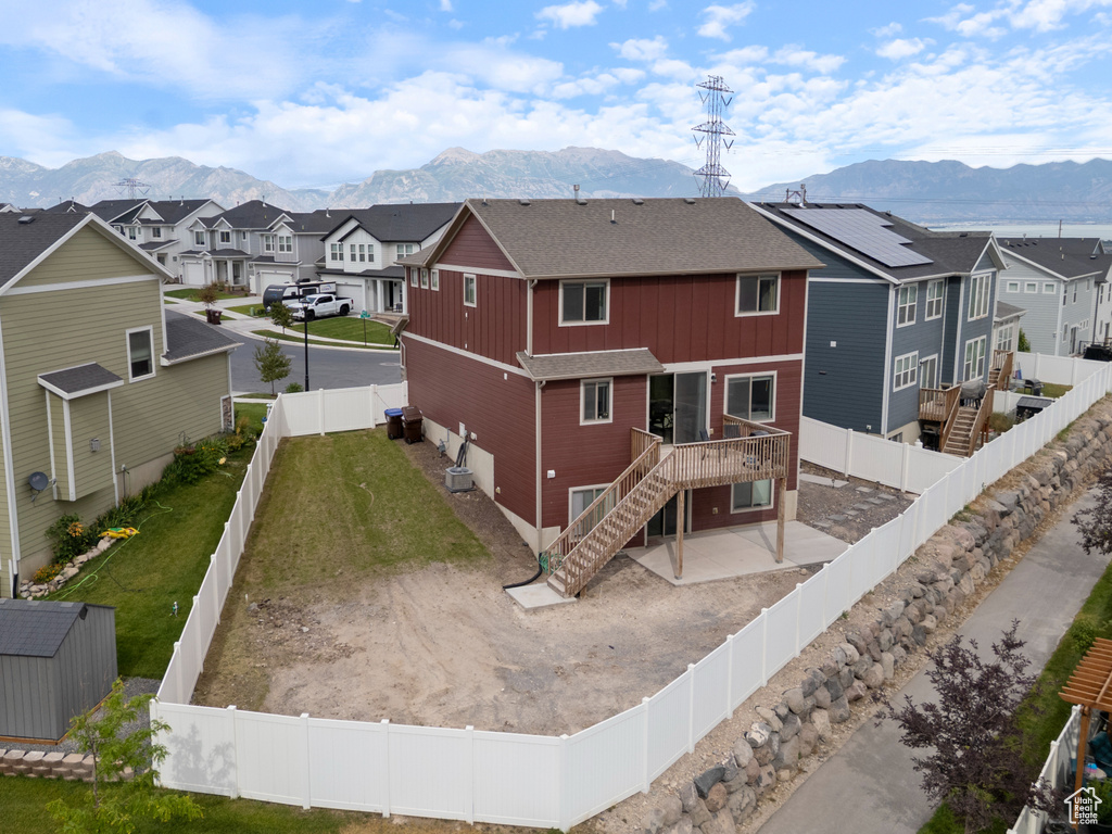 Rear view of house with stairs, a residential view, a fenced backyard, and a deck with mountain view
