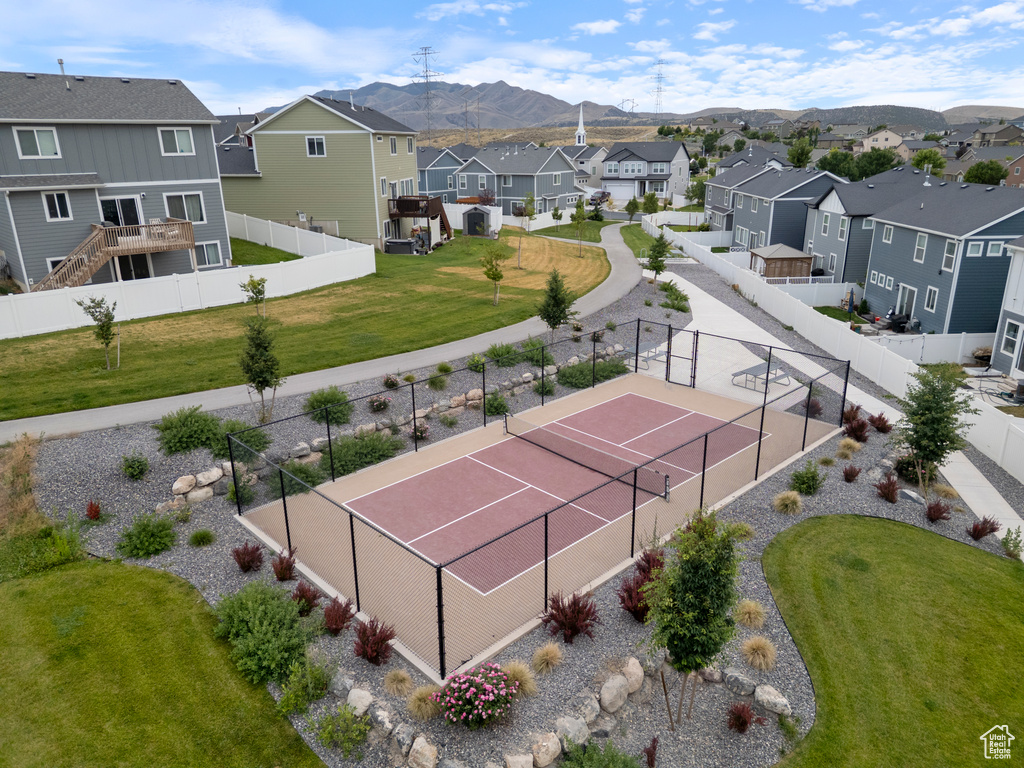 View of tennis court featuring a residential view and a mountain view