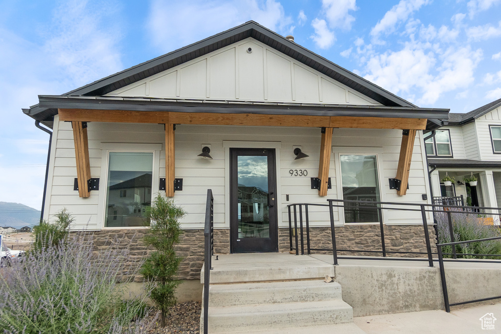 View of front of property featuring stone siding, board and batten siding, and a porch