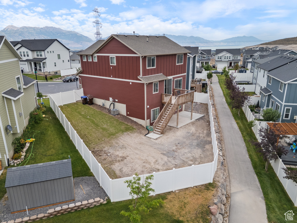 Back of property featuring a residential view, board and batten siding, stairway, and a fenced backyard