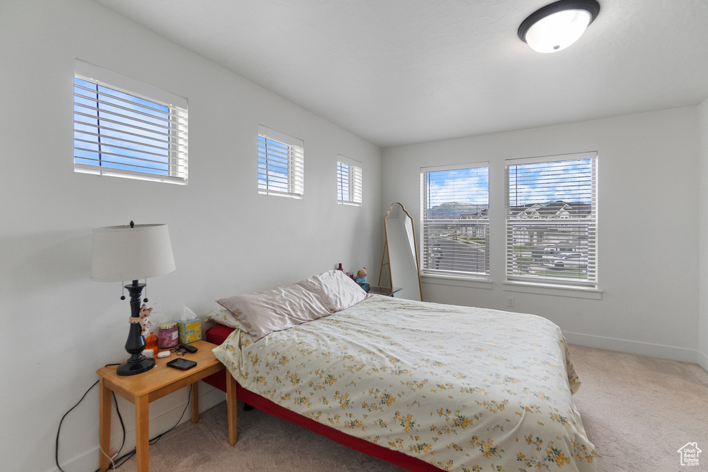Bedroom with light colored carpet and baseboards