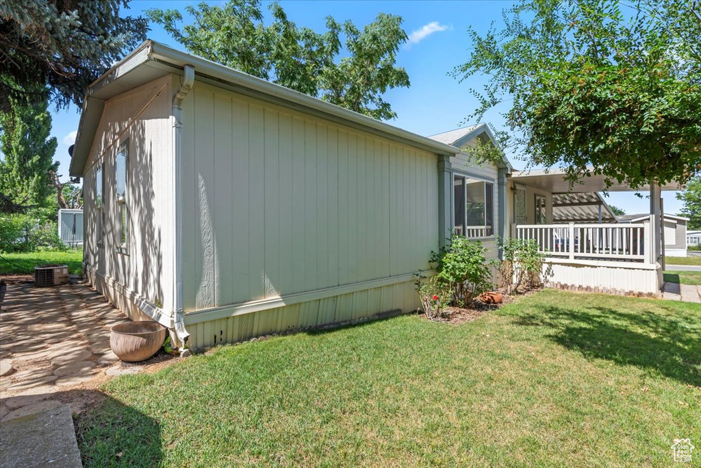 View of property exterior featuring a yard and a central air condition unit
