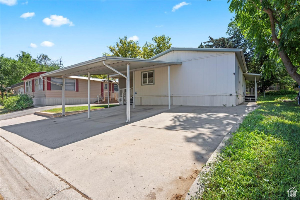 Manufactured / mobile home featuring a carport and driveway