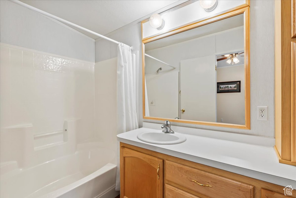 Full bathroom with vanity, shower / tub combo with curtain, and a ceiling fan