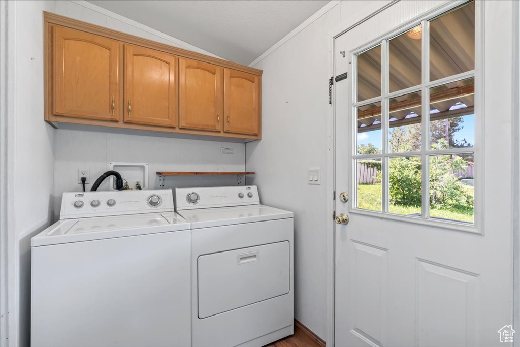 Laundry room featuring cabinet space, independent washer and dryer, and crown molding