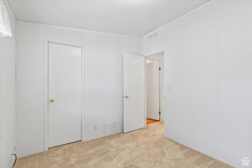 Unfurnished bedroom featuring carpet floors and crown molding