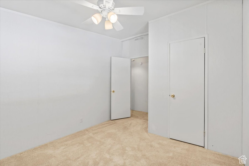 Unfurnished bedroom featuring carpet floors and ceiling fan