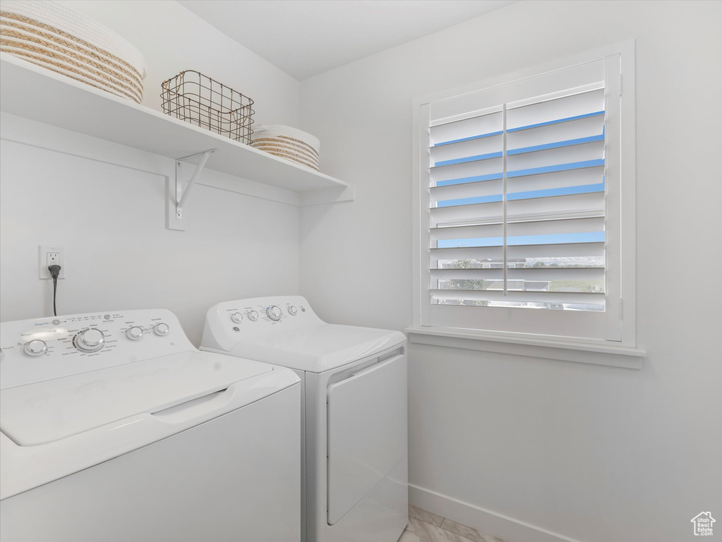 Laundry area with washer and clothes dryer and baseboards