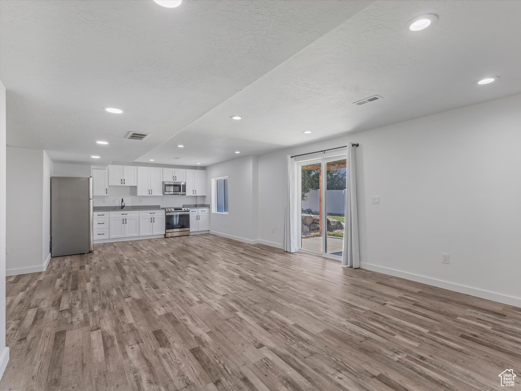 Unfurnished living room featuring light wood-style floors and recessed lighting