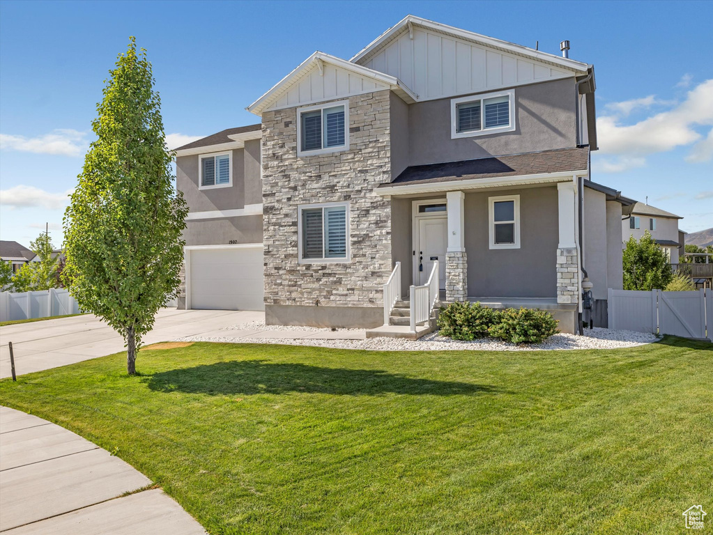 View of front of property featuring stone siding, stucco siding, and concrete driveway