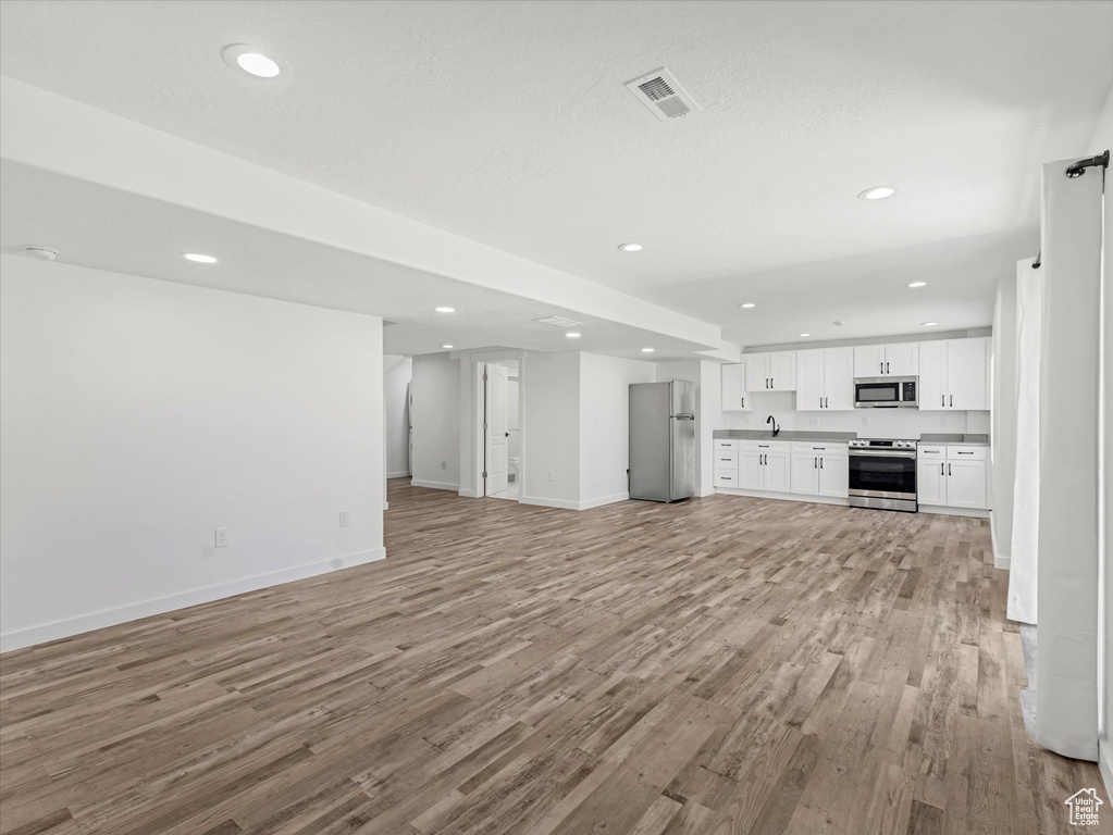 Unfurnished living room featuring light wood-style flooring and recessed lighting