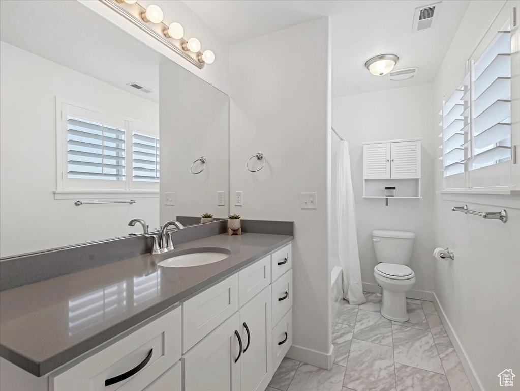 Bathroom with vanity, marble look tiles, and shower / tub combo