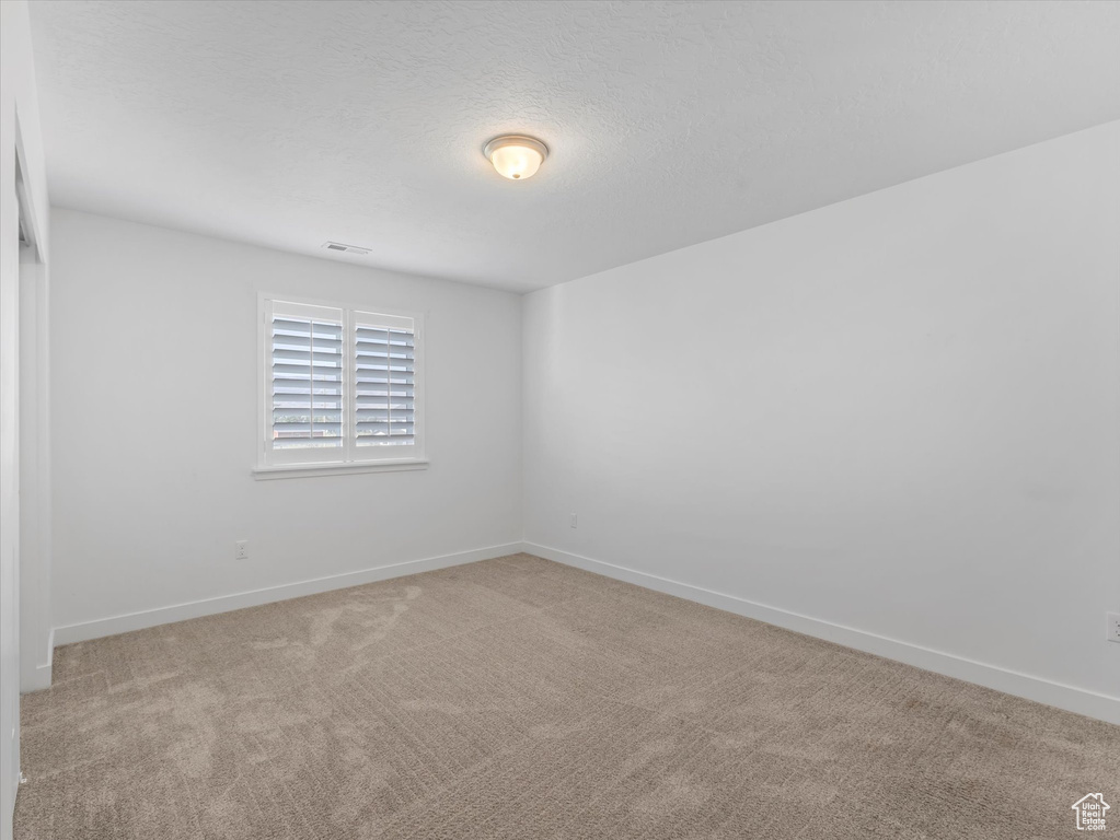 Empty room with carpet flooring and baseboards
