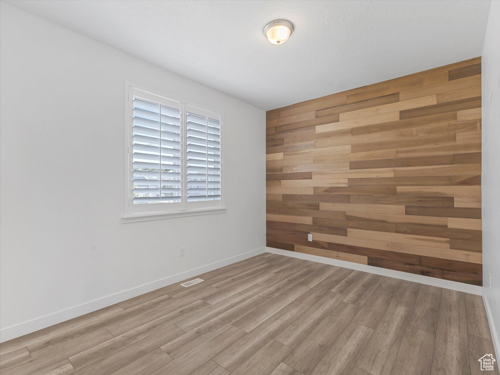 Empty room featuring wood finished floors and wooden walls