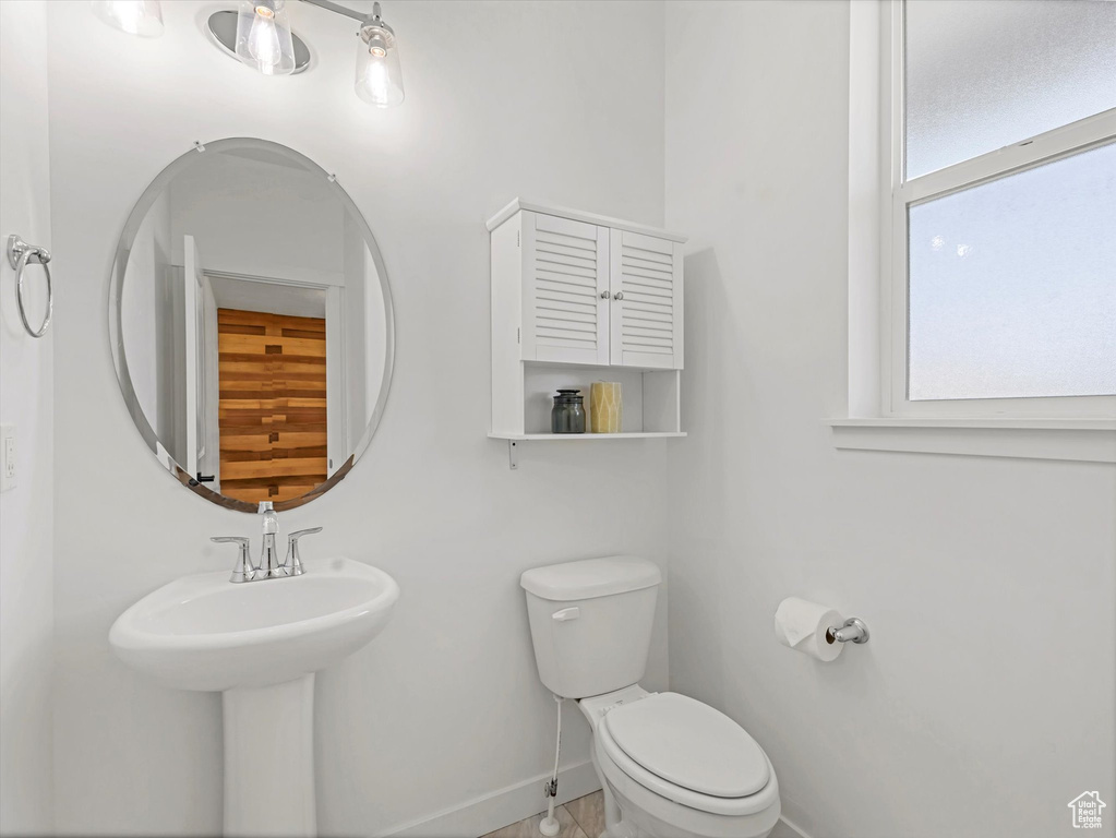 Half bathroom with baseboards and toilet