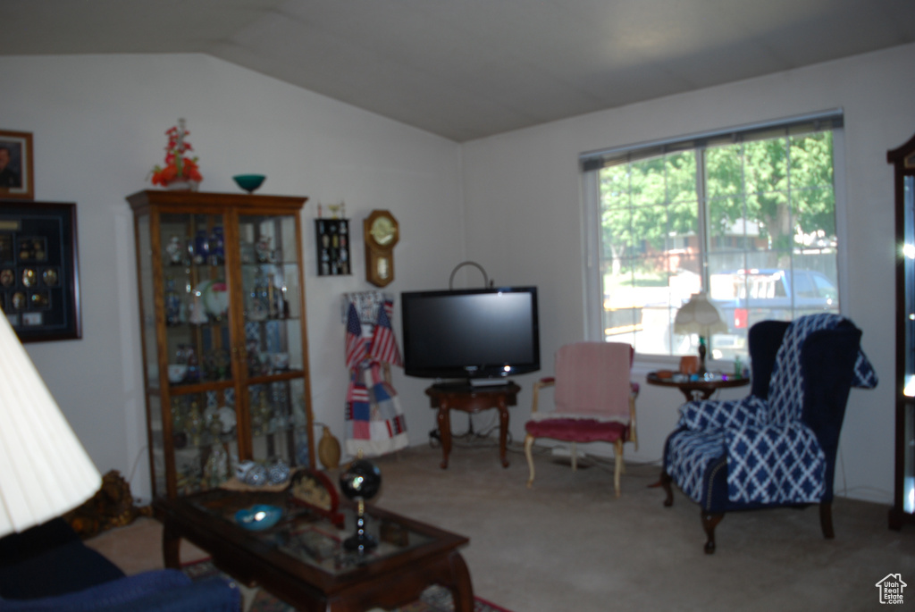 Carpeted living room with lofted ceiling