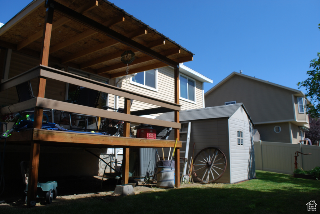 Rear view of house featuring a storage unit