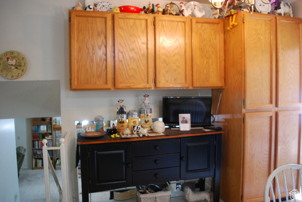 Kitchen with dark countertops, carpet, and a chandelier