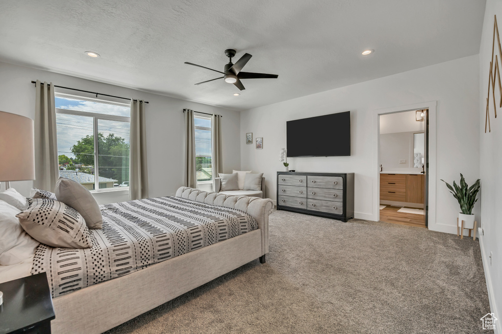 Carpeted bedroom with multiple windows, recessed lighting, connected bathroom, and ceiling fan