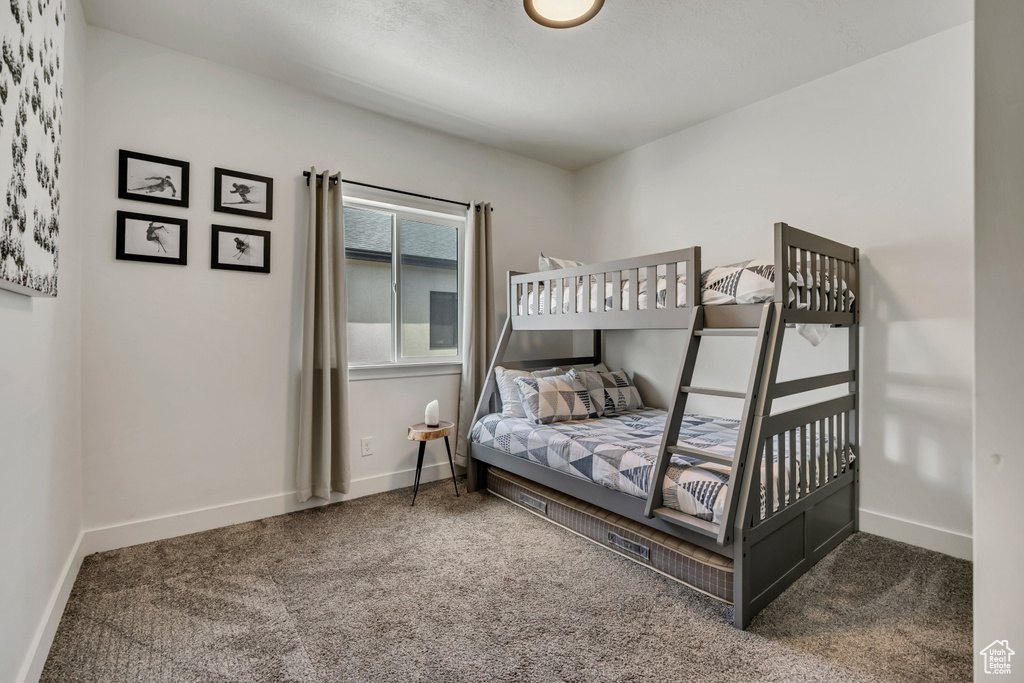 Bedroom featuring carpet and baseboards