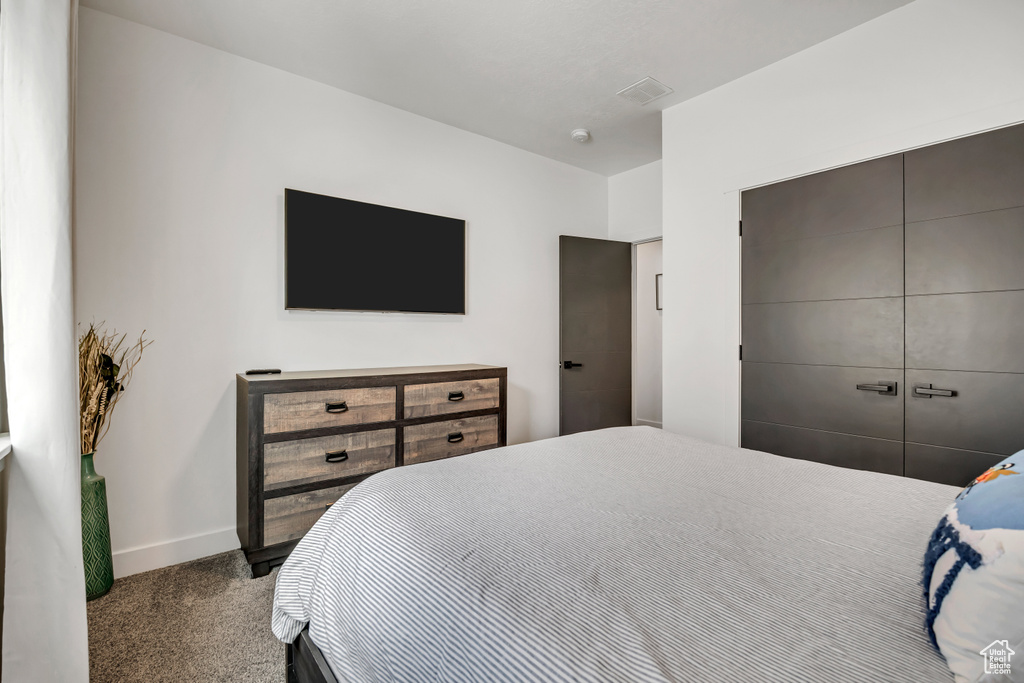 Carpeted bedroom featuring baseboards and a closet