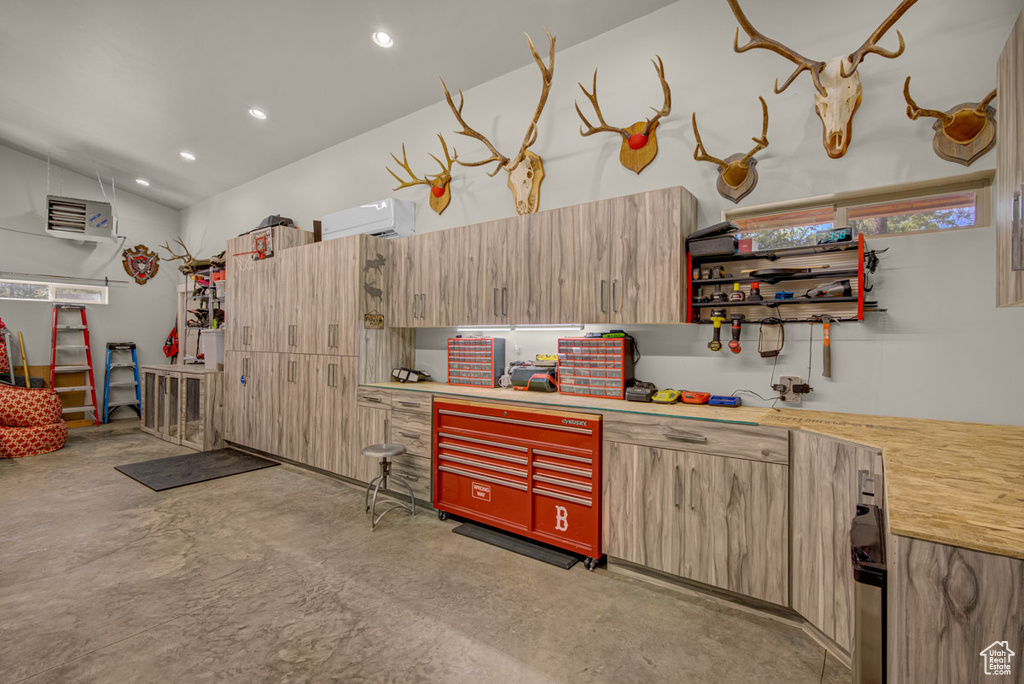 Garage with a workshop area, recessed lighting, and an AC wall unit