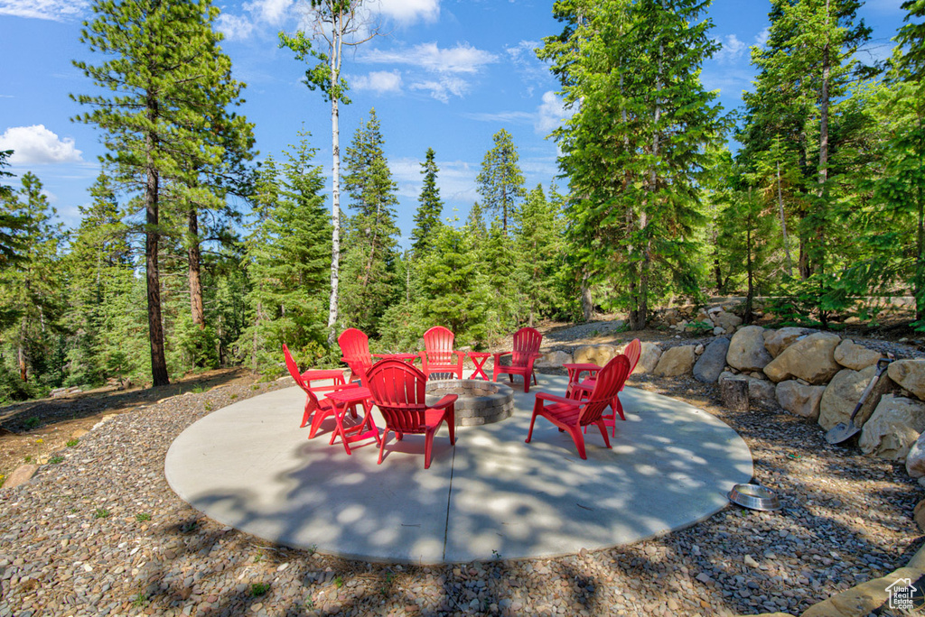 View of patio featuring a fire pit and a forest view