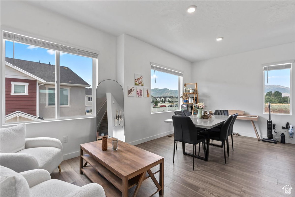 Living area with plenty of natural light, stairs, wood finished floors, and recessed lighting