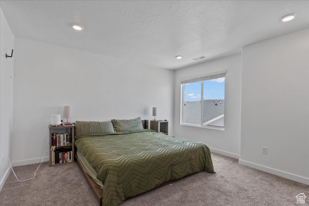 Carpeted bedroom with baseboards and recessed lighting