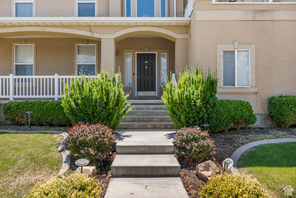 Property entrance with stucco siding and covered porch