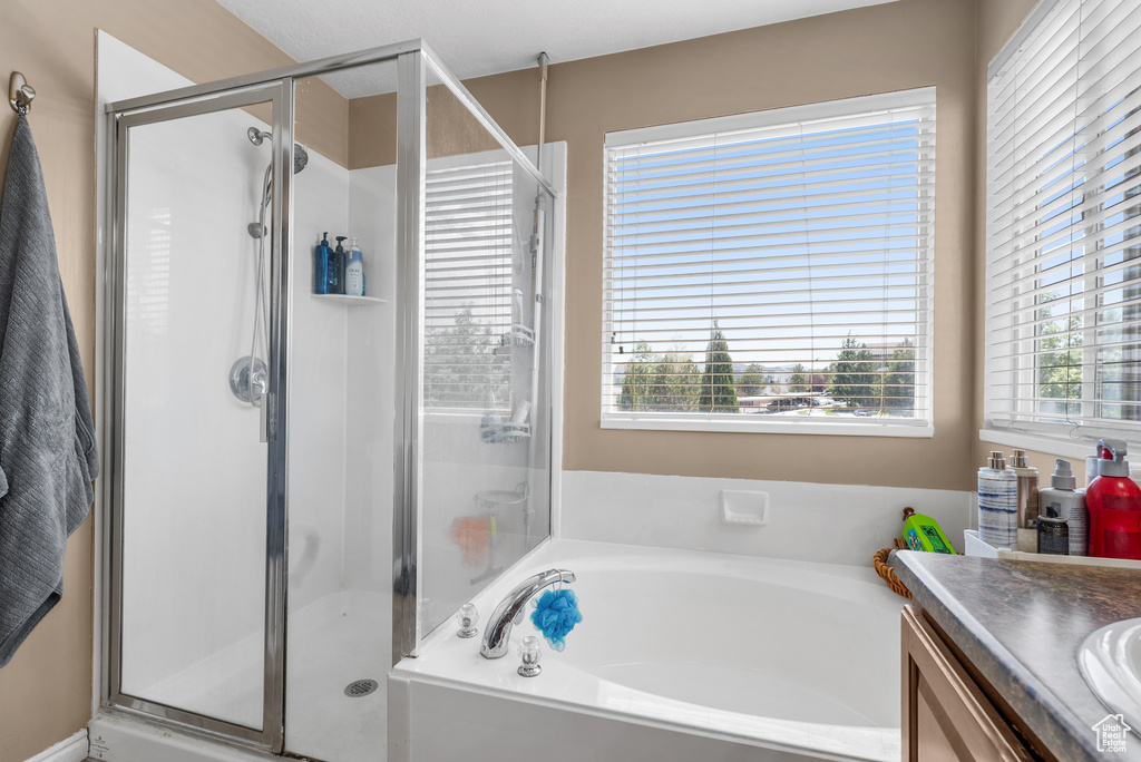 Bathroom with a bath, a shower stall, and vanity