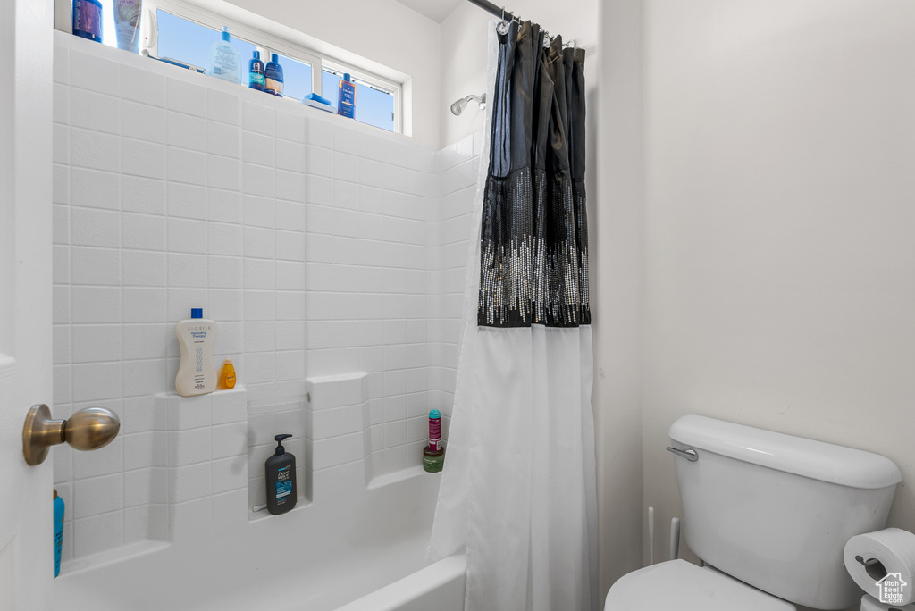 Full bathroom with shower / bath combo with shower curtain and toilet