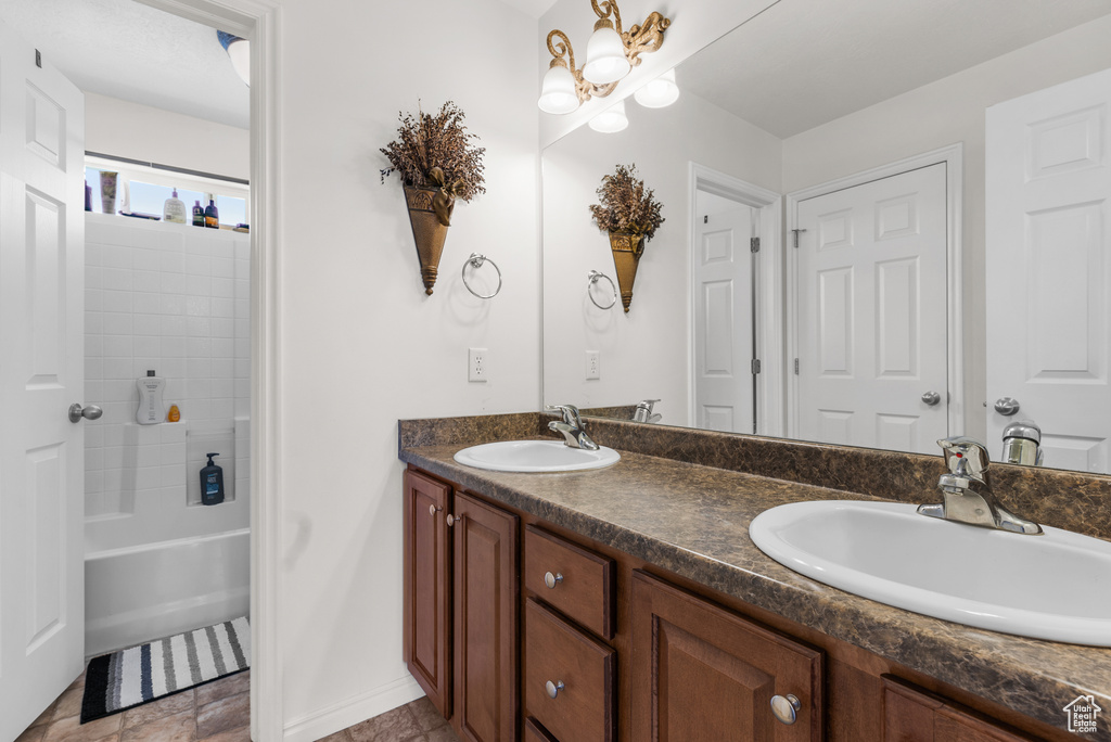 Bathroom featuring double vanity and bathing tub / shower combination