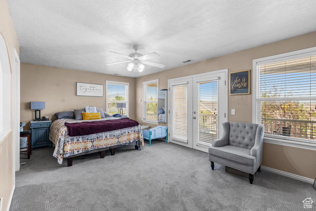 Bedroom featuring access to exterior, carpet floors, a ceiling fan, and a textured ceiling