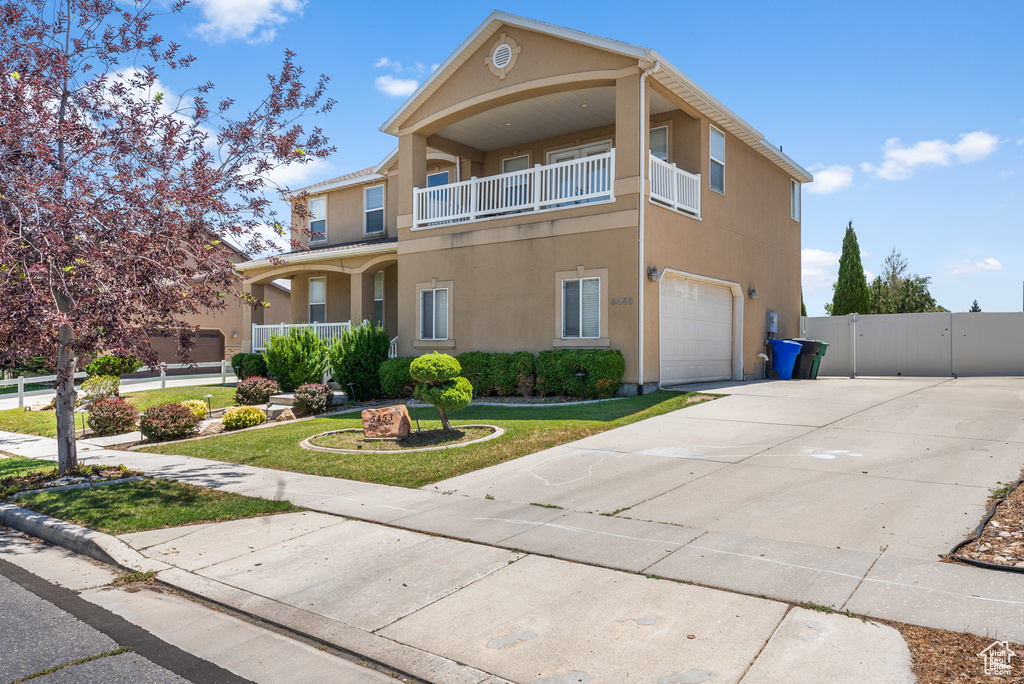 View of front of home with a garage, stucco siding, a gate, and concrete driveway