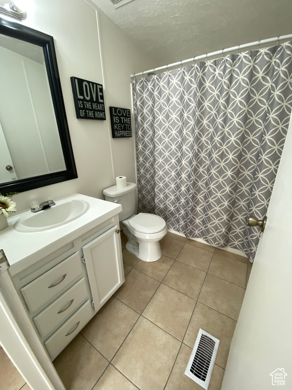 Full bathroom with vanity, tile patterned floors, a textured ceiling, and a shower with shower curtain