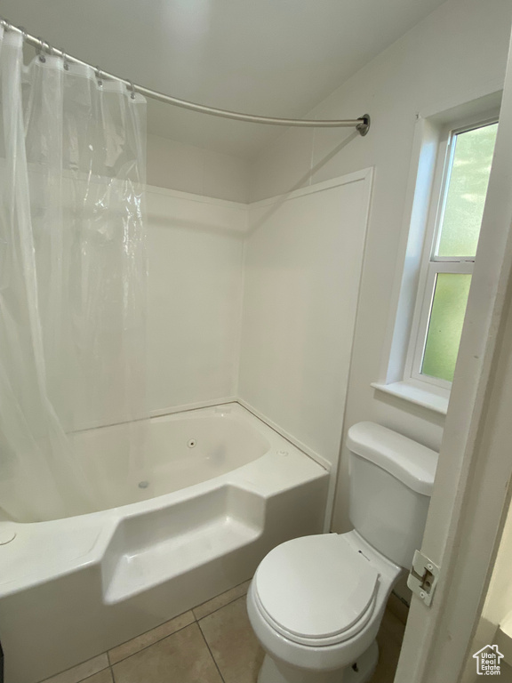 Bathroom featuring shower / bath combo and tile patterned flooring
