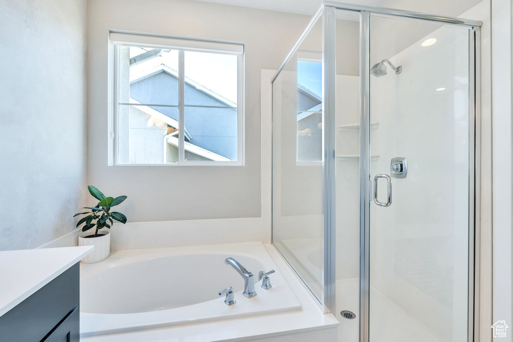 Full bathroom with vanity, a shower stall, and a bath