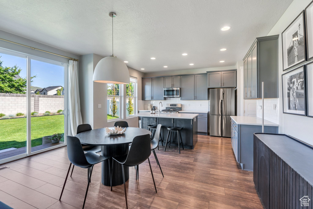 Dining space featuring dark wood-type flooring, recessed lighting, and a textured ceiling
