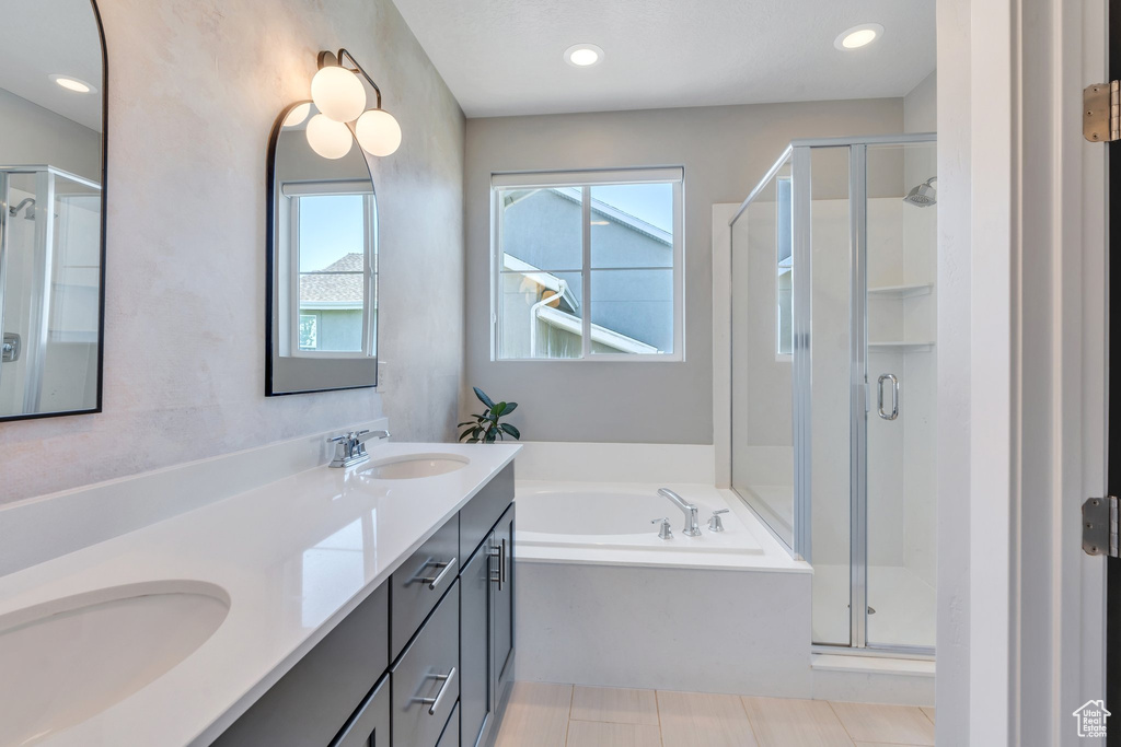 Bathroom with a stall shower, a garden tub, double vanity, and recessed lighting
