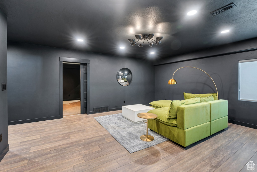 Living room with wood finished floors, recessed lighting, a chandelier, and baseboards