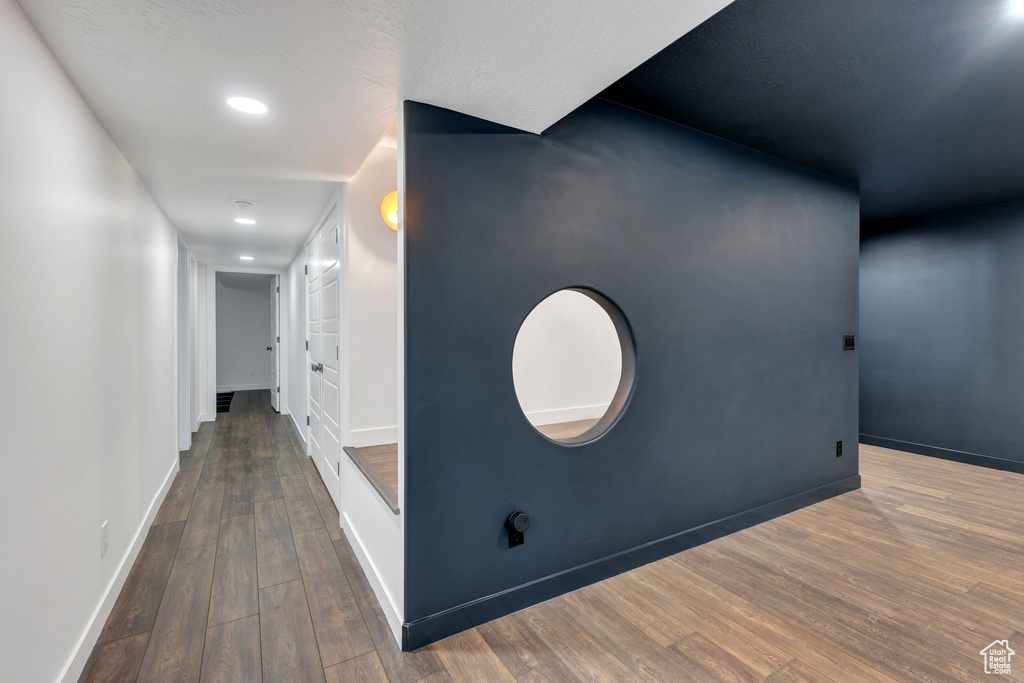 Hallway with wood finished floors, baseboards, and recessed lighting
