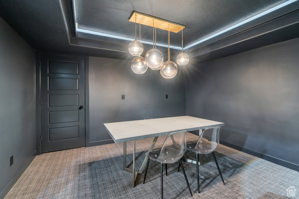 Dining space featuring carpet floors, baseboards, and a textured ceiling