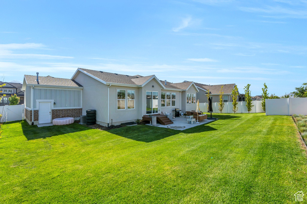 Back of house featuring a patio, a residential view, and roof with shingles