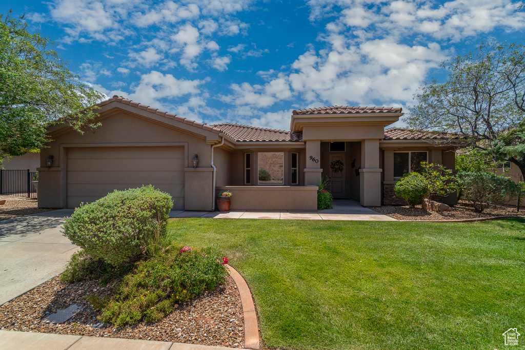 Mediterranean / spanish house with a tile roof, stucco siding, an attached garage, and concrete driveway